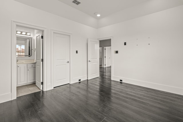 unfurnished bedroom with dark wood-type flooring and ensuite bathroom