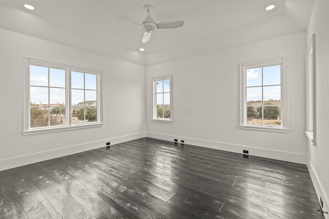 unfurnished room featuring ceiling fan, a tray ceiling, and dark hardwood / wood-style floors