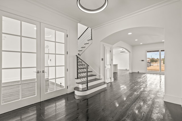 entryway with ornamental molding, dark hardwood / wood-style flooring, and french doors