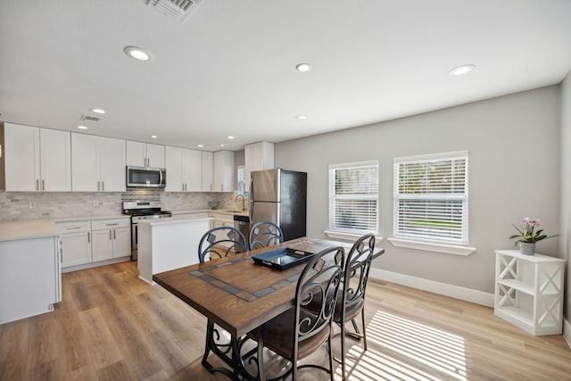 dining space with sink and light wood-type flooring