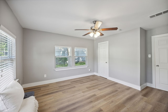 unfurnished room featuring a healthy amount of sunlight, ceiling fan, and light hardwood / wood-style flooring