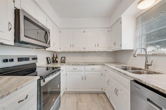 kitchen with white cabinetry, appliances with stainless steel finishes, sink, and decorative backsplash