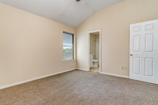 unfurnished bedroom featuring ensuite bathroom, vaulted ceiling, and light carpet