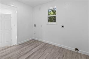 laundry room featuring electric dryer hookup and light hardwood / wood-style flooring