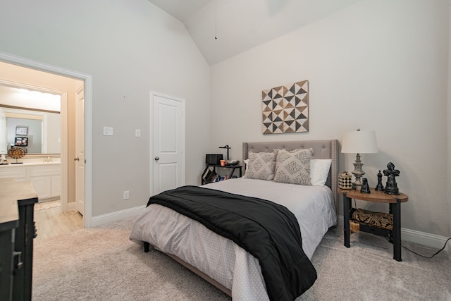 carpeted bedroom featuring ensuite bathroom and high vaulted ceiling