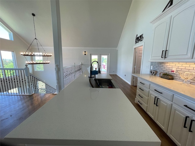 kitchen with a center island, sink, white cabinets, and decorative light fixtures