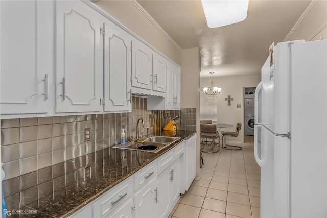 kitchen with light tile patterned floors, tasteful backsplash, white cabinets, a sink, and white appliances