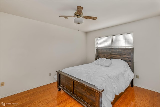 bedroom featuring baseboards, ceiling fan, and light wood finished floors