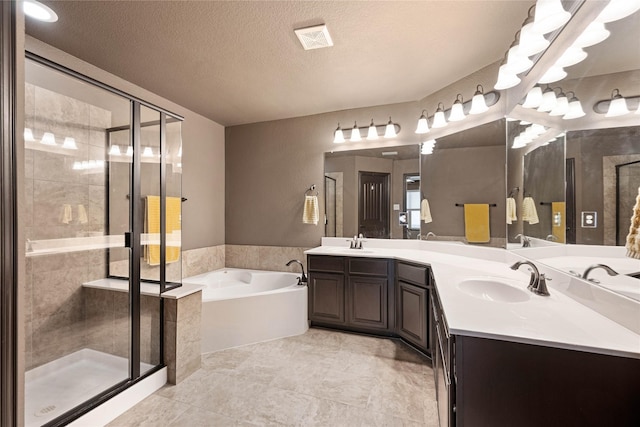 bathroom with vanity, independent shower and bath, and a textured ceiling