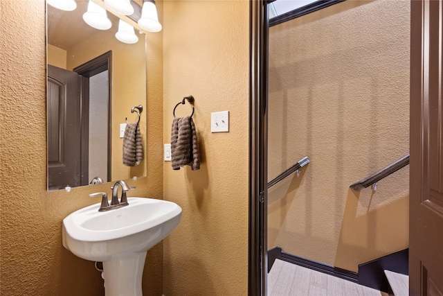 bathroom featuring hardwood / wood-style flooring and a chandelier