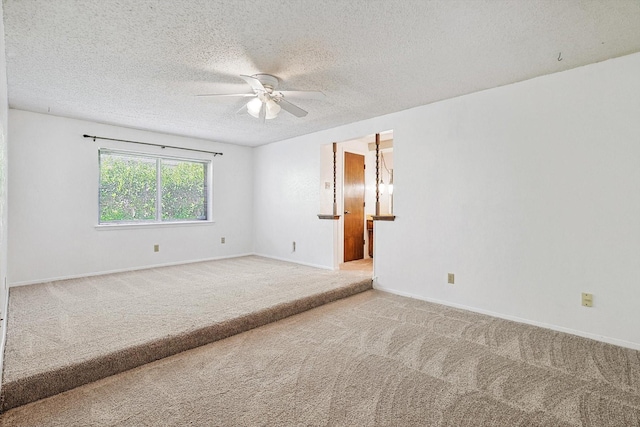 spare room featuring ceiling fan, carpet, and a textured ceiling