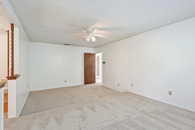 carpeted empty room featuring ceiling fan and a textured ceiling