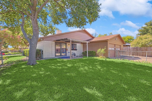 rear view of house featuring a garage and a lawn