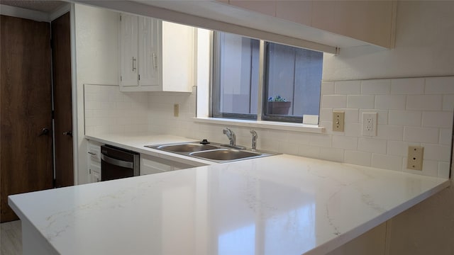 kitchen with sink, dishwasher, tasteful backsplash, light stone countertops, and white cabinets