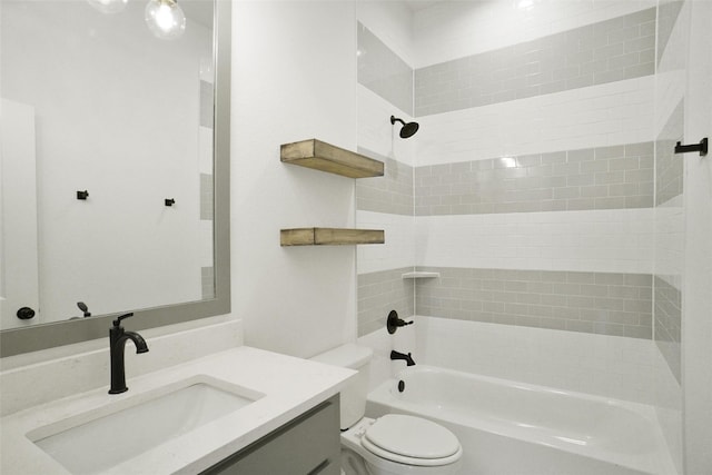 full bathroom featuring tiled shower / bath, vanity, and toilet