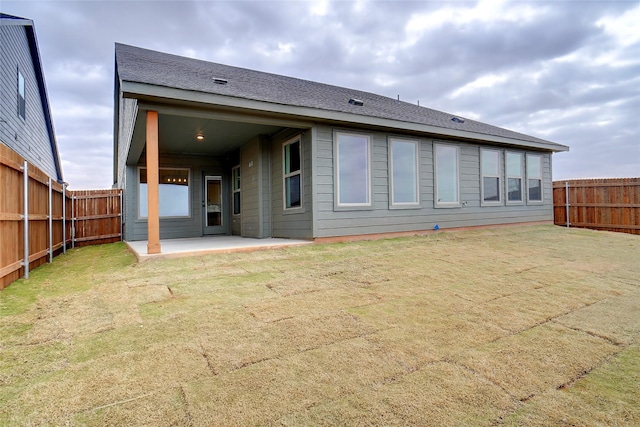 rear view of property featuring a patio and a lawn