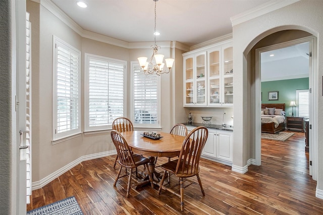 dining room featuring a notable chandelier, arched walkways, ornamental molding, recessed lighting, and dark wood-style floors