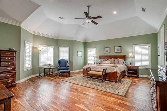 bedroom with baseboards, lofted ceiling, wood finished floors, and visible vents