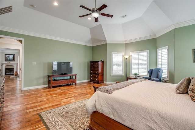 bedroom with light wood-style floors, arched walkways, baseboards, and visible vents