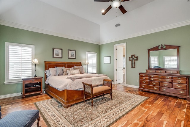 bedroom with visible vents, high vaulted ceiling, wood finished floors, and multiple windows