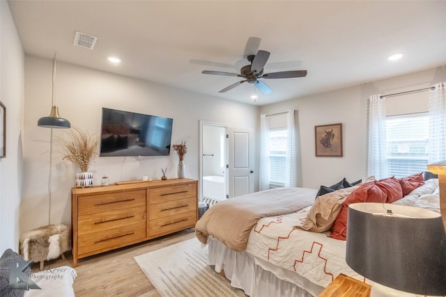 bedroom featuring ensuite bathroom, light hardwood / wood-style flooring, and ceiling fan