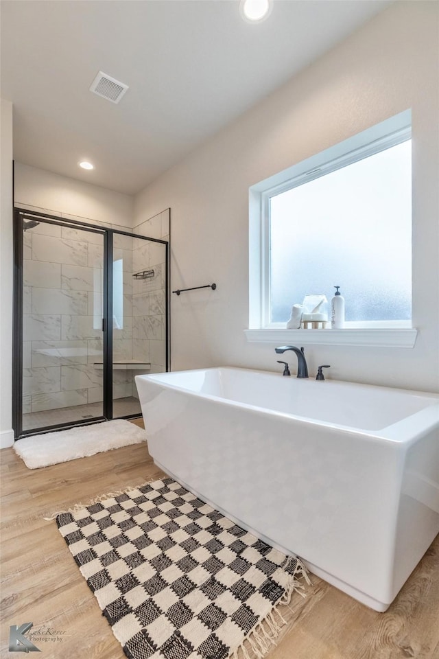 bathroom featuring separate shower and tub and hardwood / wood-style flooring