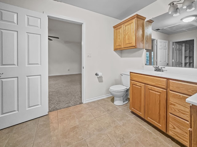 bathroom with toilet, tile patterned floors, vanity, and ceiling fan