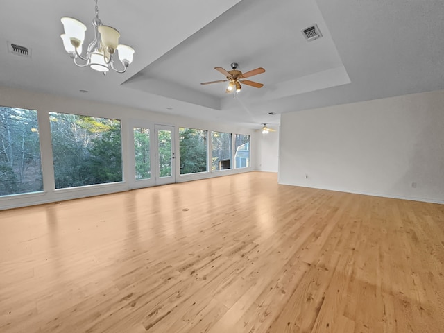 1476 W Holly Trl, Holly Lake Ranch, TX 75765 - unfurnished living room featuring ceiling fan with notable chandelier, a raised ceiling, visible vents, and light wood-style floors