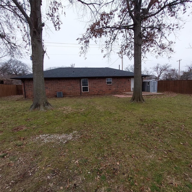 exterior space with a shed, a lawn, and central air condition unit