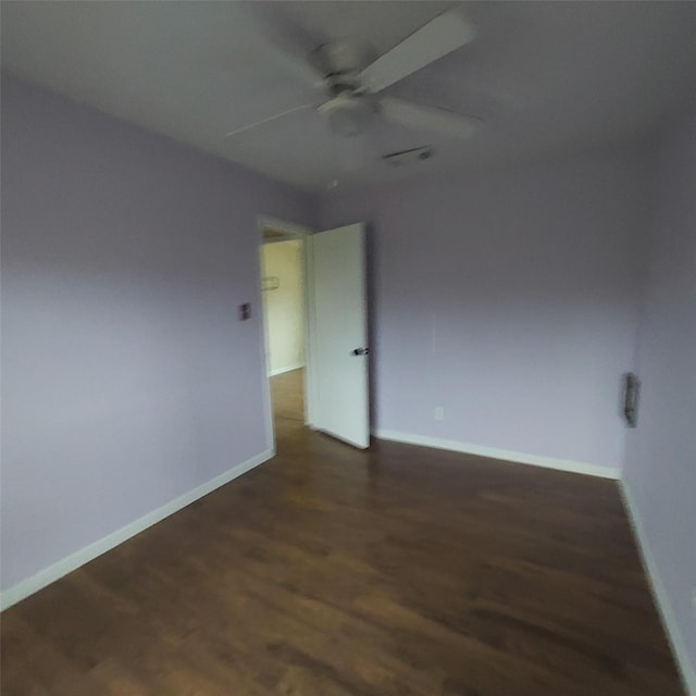 spare room with ceiling fan and dark hardwood / wood-style floors