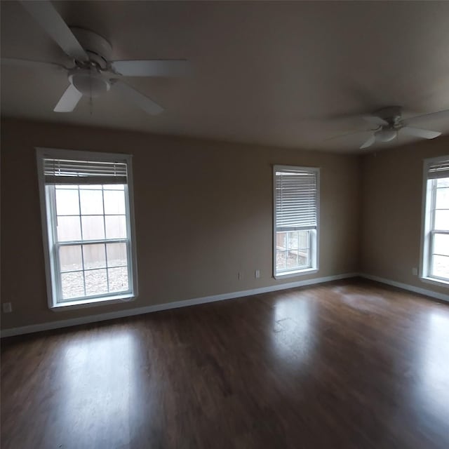 empty room with dark wood-type flooring and ceiling fan