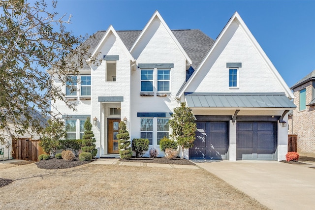 view of front of property with brick siding, concrete driveway, an attached garage, a standing seam roof, and metal roof