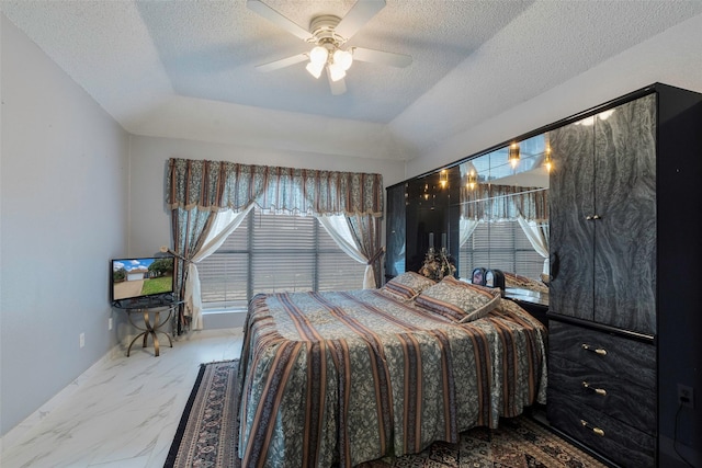 bedroom with ceiling fan and a textured ceiling