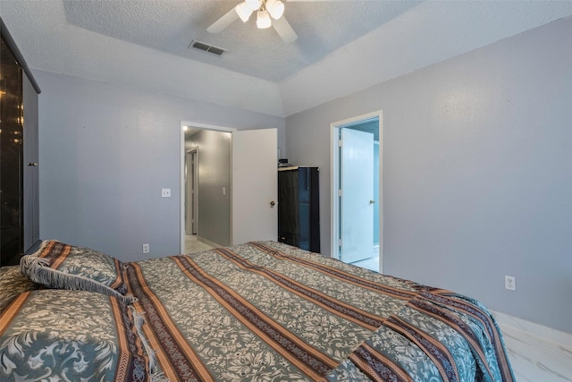 bedroom featuring lofted ceiling, ceiling fan, and a textured ceiling