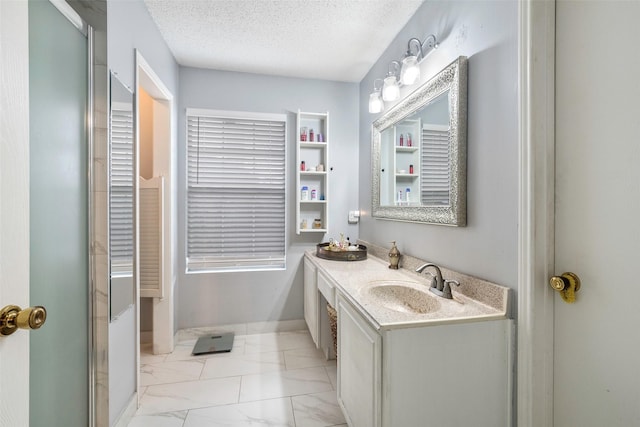 bathroom featuring a shower with door, vanity, and a textured ceiling