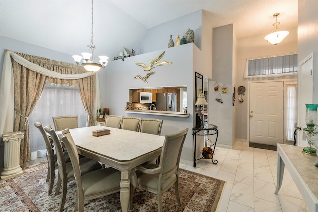 dining area with a chandelier and high vaulted ceiling