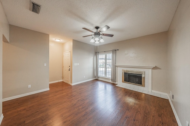 unfurnished living room with ceiling fan, a textured ceiling, a fireplace, and wood-type flooring