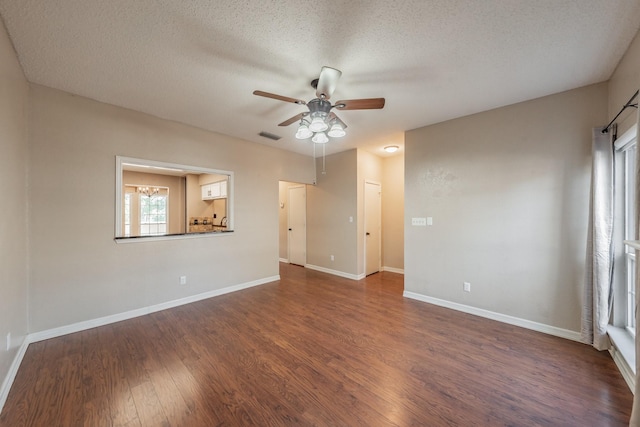 spare room featuring dark hardwood / wood-style flooring, ceiling fan, and a textured ceiling