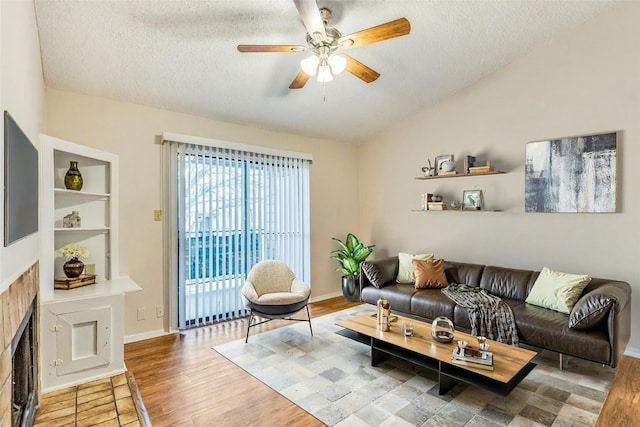 living room with a textured ceiling, vaulted ceiling, and wood-type flooring