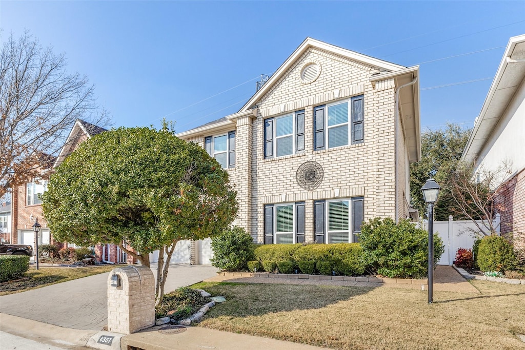 4307 N Capistrano Dr, Dallas, TX 75287 - view of front of home featuring concrete driveway, a front yard, and brick siding