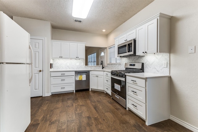kitchen featuring a sink, light countertops, a textured ceiling, stainless steel appliances, and backsplash
