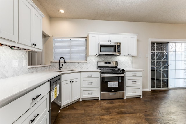 kitchen featuring tasteful backsplash, a sink, light countertops, stainless steel appliances, and white cabinetry
