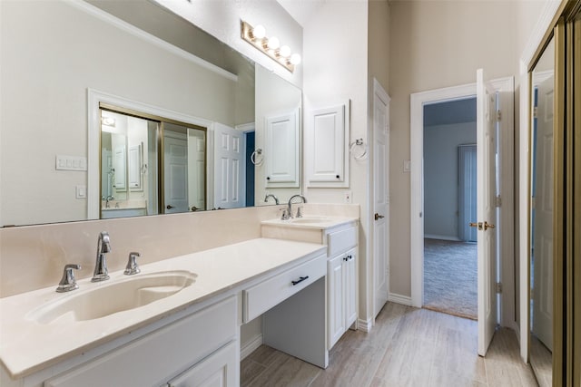 bathroom with double vanity, a sink, and wood finished floors