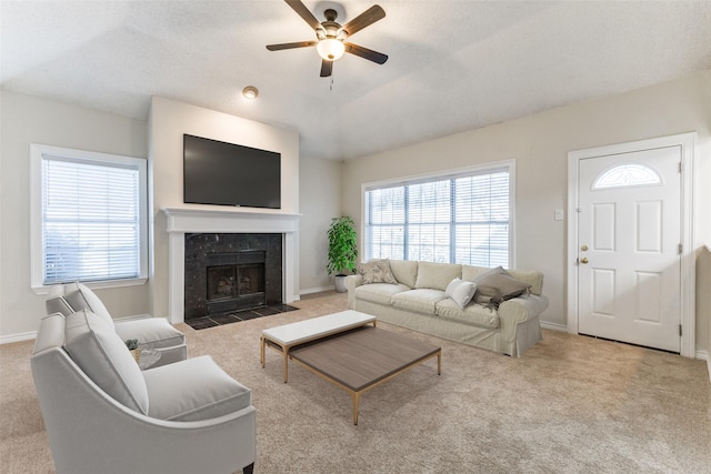 carpeted living room with baseboards, ceiling fan, and a fireplace