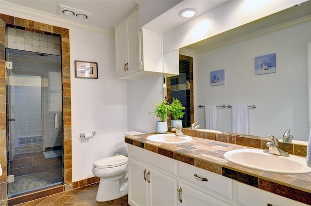 bathroom featuring ornamental molding, a sink, toilet, and double vanity