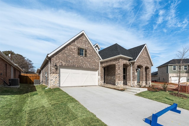 view of front of property featuring a garage, central AC unit, and a front lawn