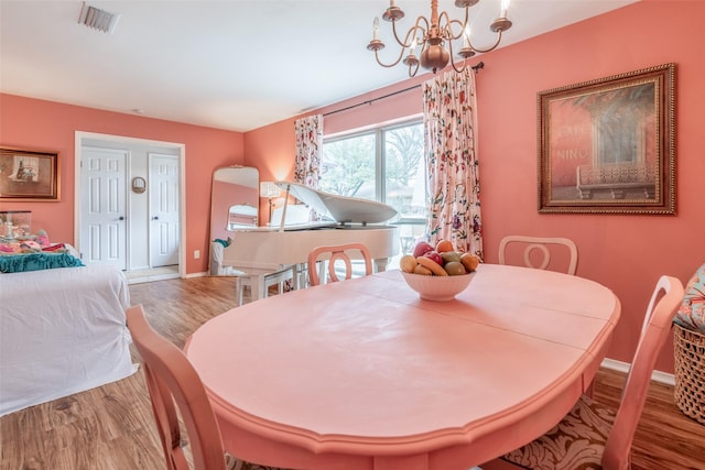 dining space featuring hardwood / wood-style floors and a chandelier