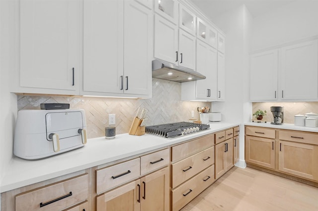 kitchen featuring stainless steel gas stovetop, tasteful backsplash, light brown cabinetry, and white cabinetry