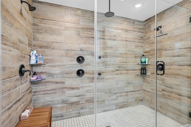 bathroom featuring a shower with shower door and wood walls