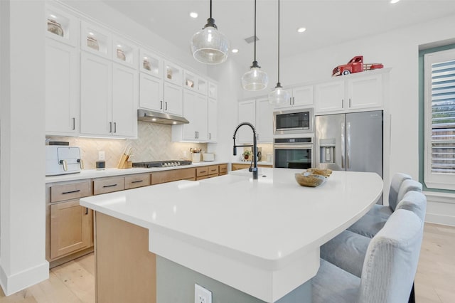 kitchen with stainless steel appliances, white cabinetry, and a large island